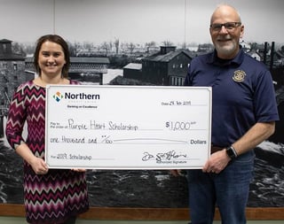 Photo of Alexa Bennett posing with Northern CU scholarship check