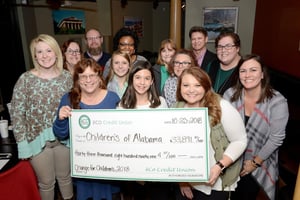 Photo of eCO employees holding the 2018 donation made to Childrenâs of Alabama