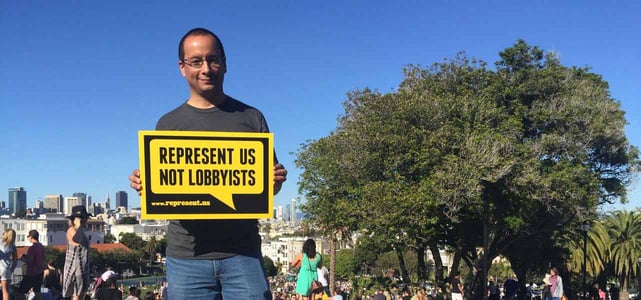 Photo of man holding up RepresentUs sign Photo of man holding up RepresentUs sign