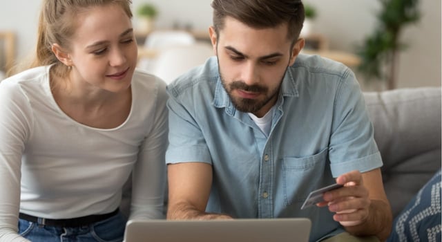 Photo of a woman and man online with a credit card