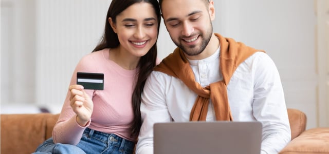 Photo of a couple online holding a credit card