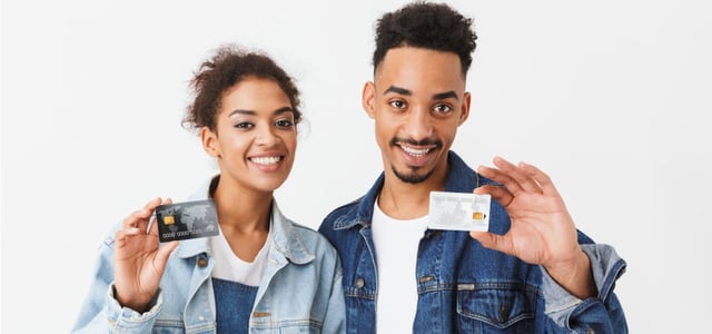 Photo of two people holding up a credit card Photo of two people holding up a credit card