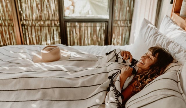 Photo of a woman in bed at the Treehouse Hotel at Acre Baja in Mexico.