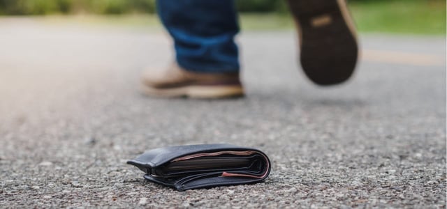 Photo of a man walking away after dropping his wallet.