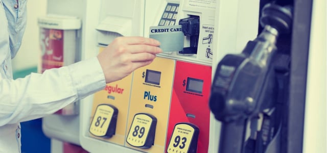 Photo of a woman inserting a credit card to pay at a fuel pump. Photo of a woman inserting a credit card to pay at a fuel pump.