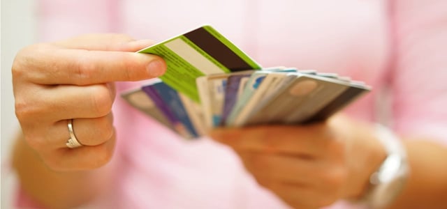 Woman choosing a credit card among several options.