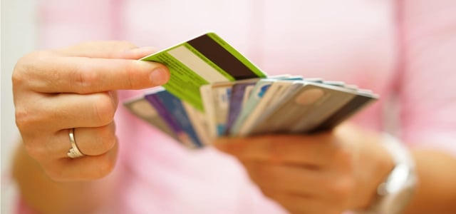 Woman choosing from among several credit cards.