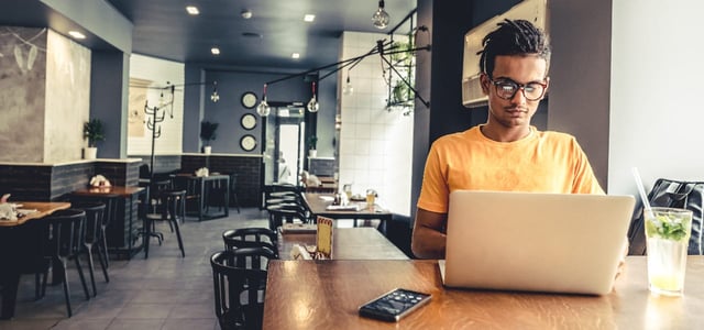 Man working on a laptop in a restaurant