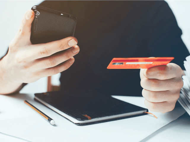 Image of person entering credit card information into smartphone Image of person entering credit card information into smartphone