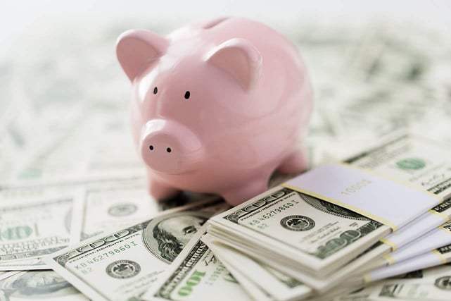 business, finance, investment, saving and corruption concept - close up of dollar cash money and piggy bank on table