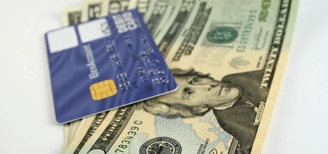 A credit card on top of American dollars A credit card on top of American dollars