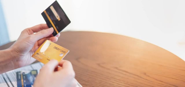 A female hand holding and choosing the type of credit card with the application form for bank approved credit card A female hand holding and choosing the type of credit card with the application form for bank approved credit card