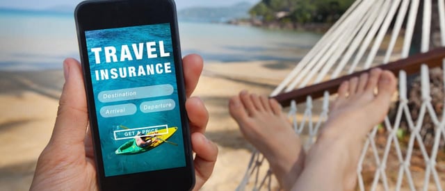 A man on a hammock at a beach holding a phone with the words travel insurance on it A man on a hammock at a beach holding a phone with the words travel insurance on it