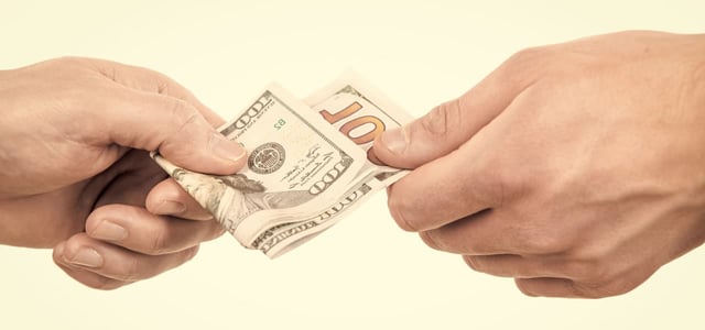 Two hands exchanging $100 bills Two hands exchanging $100 bills