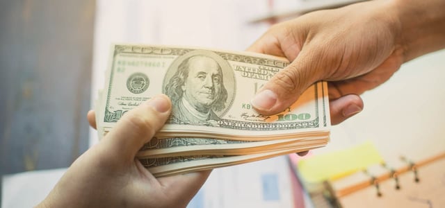 Hands exchanging a stack of $100 bills Hands exchanging a stack of $100 bills