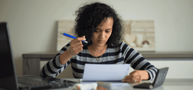 Woman writing a letter, holding a pen and paper