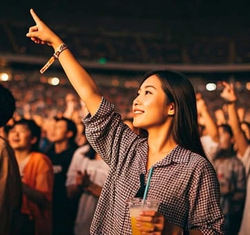 concertgoer with wristband and beverage