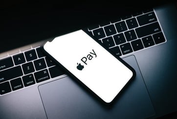 Photo of Apple Pay on a Phone and a Laptop Photo of Apple Pay on a Phone and a Laptop