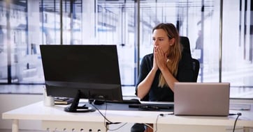 concerned woman with a laptop and desktop