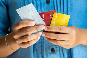 hands holding three credit cards hands holding three credit cards