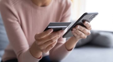 a woman using a credit card to shop on phone graphic a woman using a credit card to shop on phone graphic
