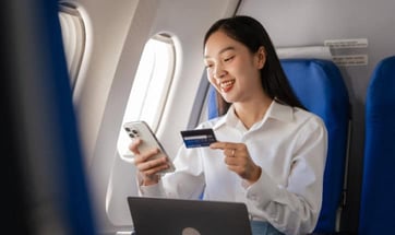 a woman in an airplane with a credit card graphic