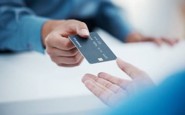 a person handing their credit card to a salesperson graphic a person handing their credit card to a salesperson graphic