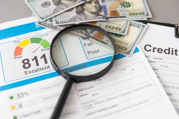 credit score documents and cash under magnifying glass credit score documents and cash under magnifying glass