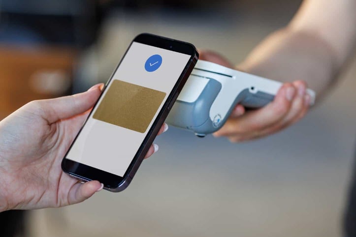 Photo of a smartphone and contactless payment terminal